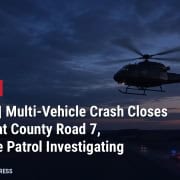 AI-generated illustration: medical helicopter over a highway at dusk with the headline Bascom multi-vehicle crash closes U.S. 224 at County Road 7, Developing